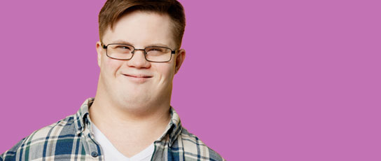 Person in a plaid shirt against a pink background.