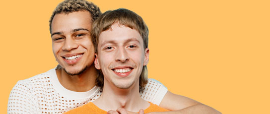 Two people in white and orange clothes against an yellow-orange background.