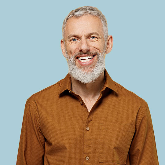 Man in a brown shirt against a blue background. 